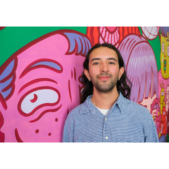 a man in front of a multicolored wall