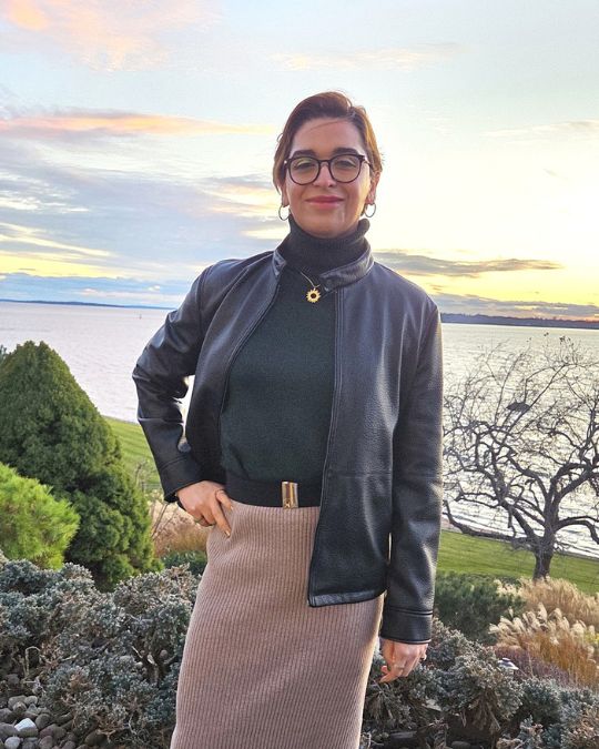 A woman standing in front of a sunset