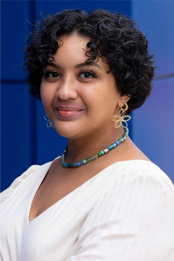 a woman in a white shirt in front of a blue background.