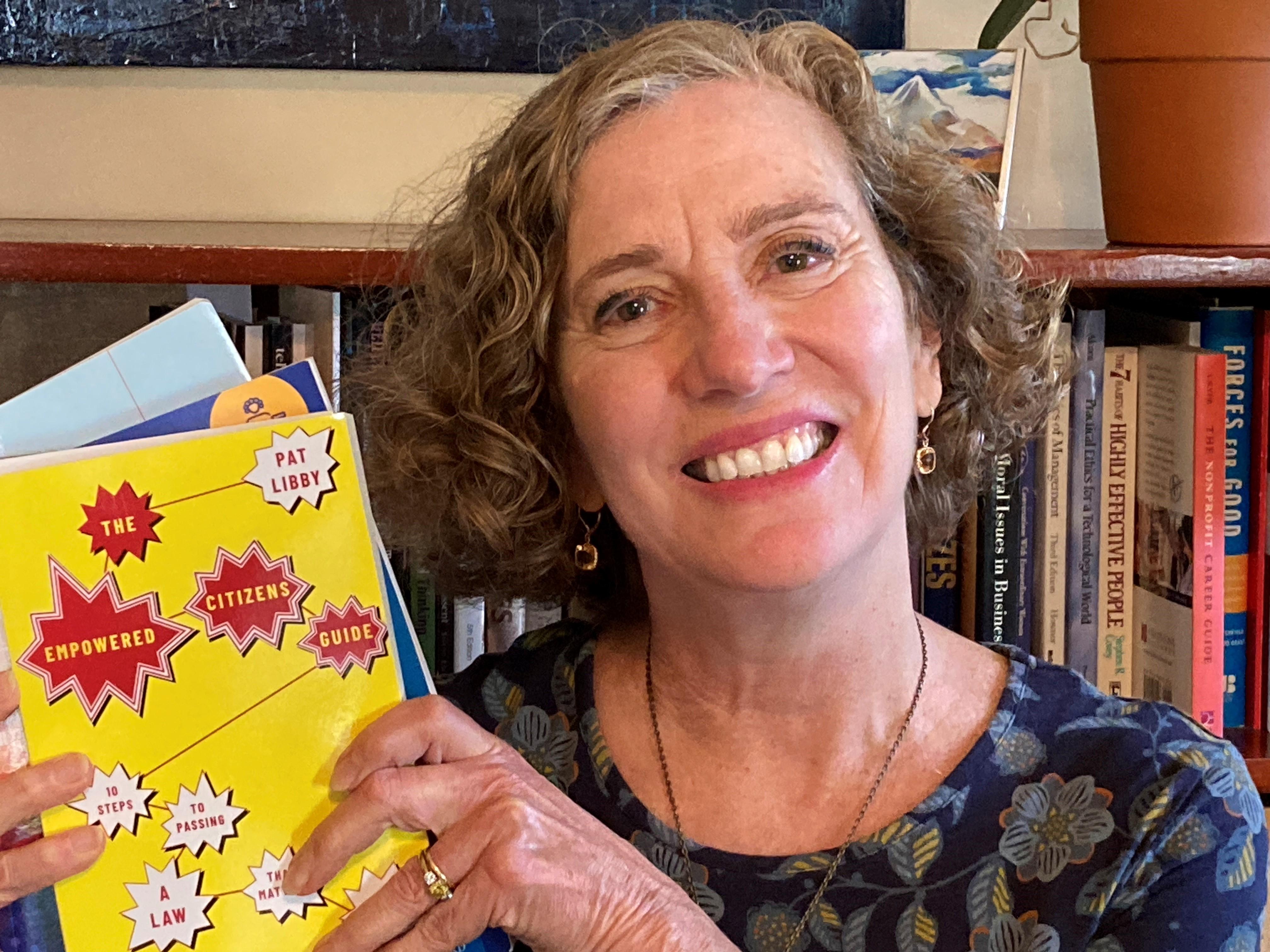 A woman holding up a yellow book