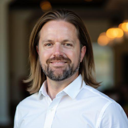 A man in a white shirt in front of a blurred background