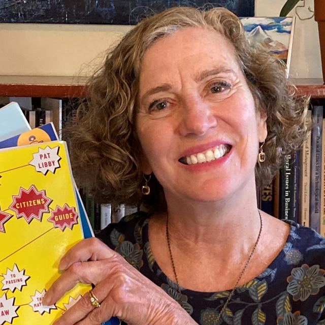 A woman holding up a yellow book